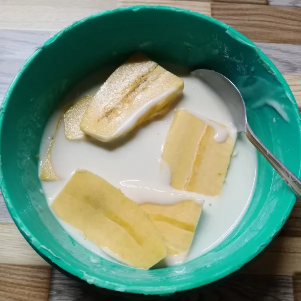 Masukkan irisan pisang, aduk rata sampai terbalut adonan tepung.