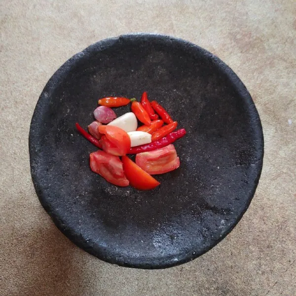 Dalam cobek, siapkan bahan sambal : cabai rawit, cabai merah keriting, bawang merah, dan bawang putih. Kemudian goreng terlebih dahulu.