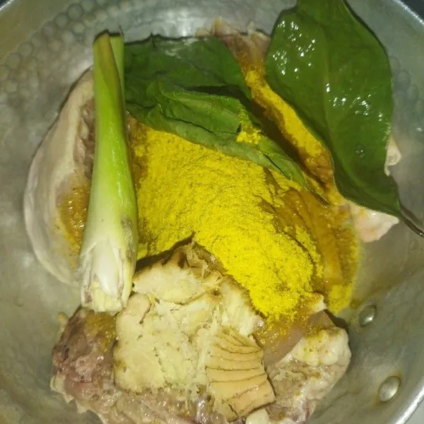 Siapkan panci, masukkan potongan daging ayam, bumbu instan ayam ungkep, daun salam, lengkuas dan serai.