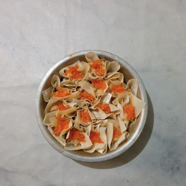 Taburi dengan parutan wortel di atas siomay.