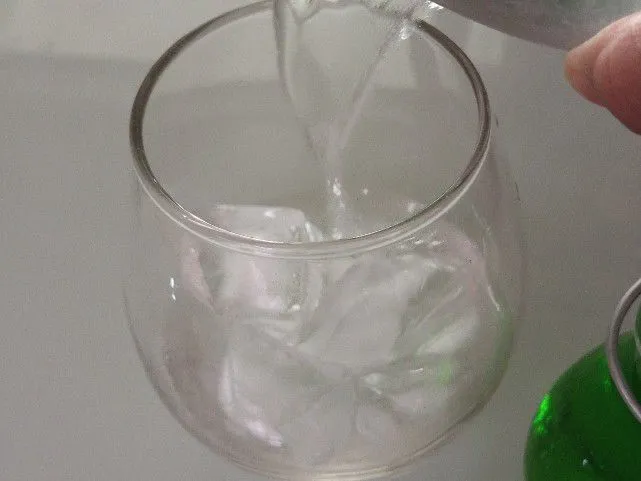 Pertama, siapkan air soda dan es batu ke dalam gelas.