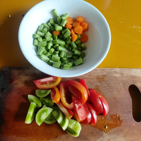 Potong kecil-kecil buncis, wortel dan tomat.