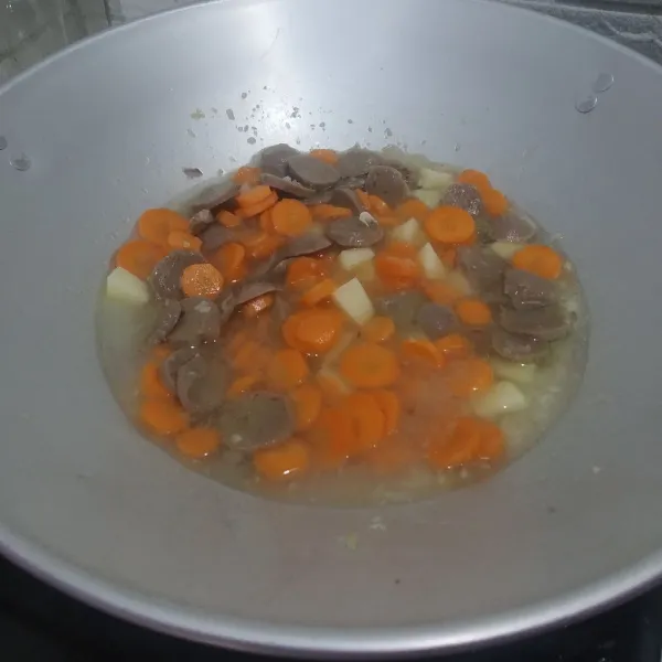 Masukan bakso aduk sebentar,tambahkan air,masukan wortel & kentang nya,masak hingga setengah matang.