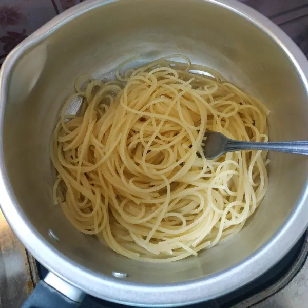 Rebus air dan 1 sendok makan minyak hingga mendidih, setelah mendidih masukkan spaghetti, rebus sampai empuk.