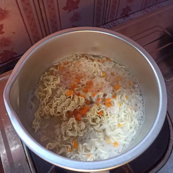 Rebus air hingga mendidih, setelah mendidih, masukkan mie dan wortel rebus selama 3 menit.