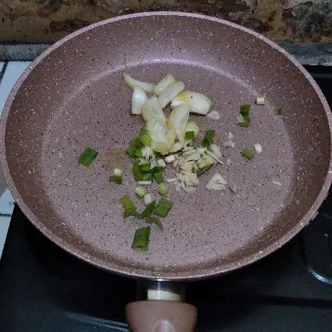 Tumis bawang putih cincang, bawang bombai, dan daun bawang hingga harum.