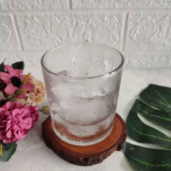 Siapkan es batu, salin ke dalam gelas saji. Kemudian beri symple syrup