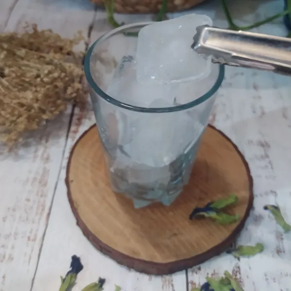 Masukkan es batu ke dalam gelas saji.