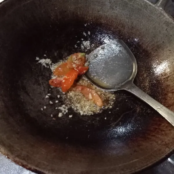 Tumis bawang putih cincang dan irisan tomat sampai matang.