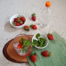 Tambahkan potongan strawberry dan daun mint