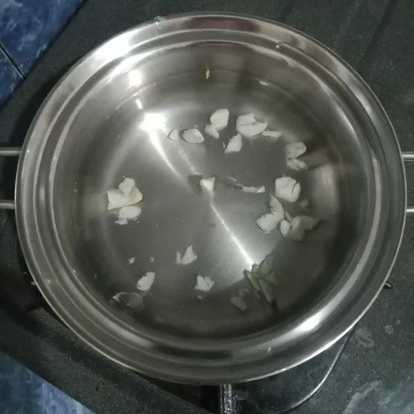 Dalam panci, didihkan air bersama bawang putih.