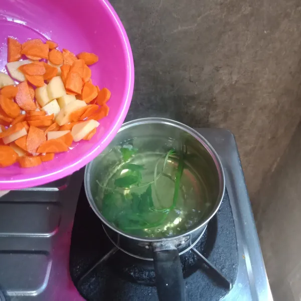 Masukkan daun seledri, wortel dan kentang, masak sampai setengah empuk.