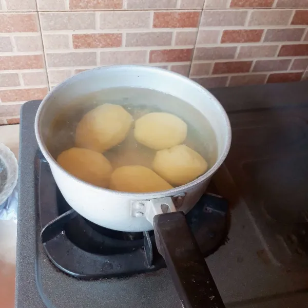 Kupas kentang dan cuci bersih. Rebus dalam air mendidih sampai setengah matang, angkat dan tiriskan.