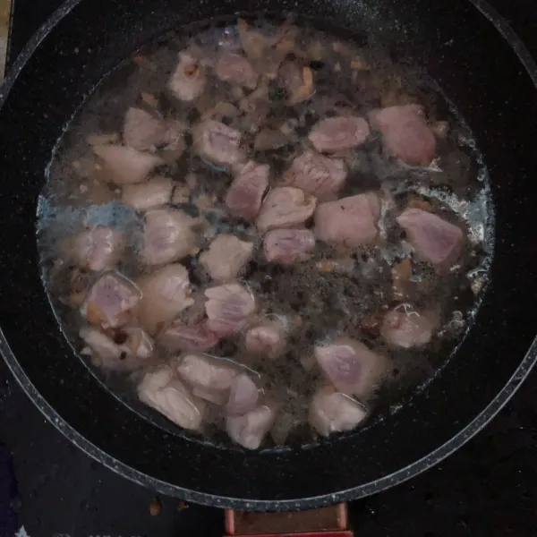 Masukkan daging dan bumbu, aduk rata lalu beri air. Lalu masukkan wortel. Diamkan hingga daging matang.