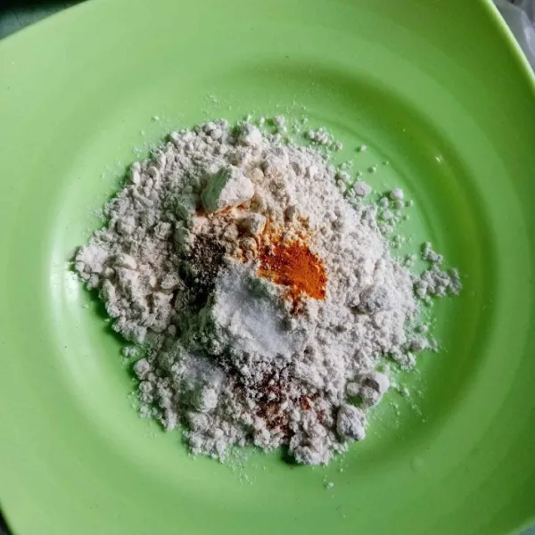 Masukkan terigu, garam, kunyit bubuk, lada bubuk, ketumbar bubuk dalam wadah lalu tuang air secukupnya dan aduk rata