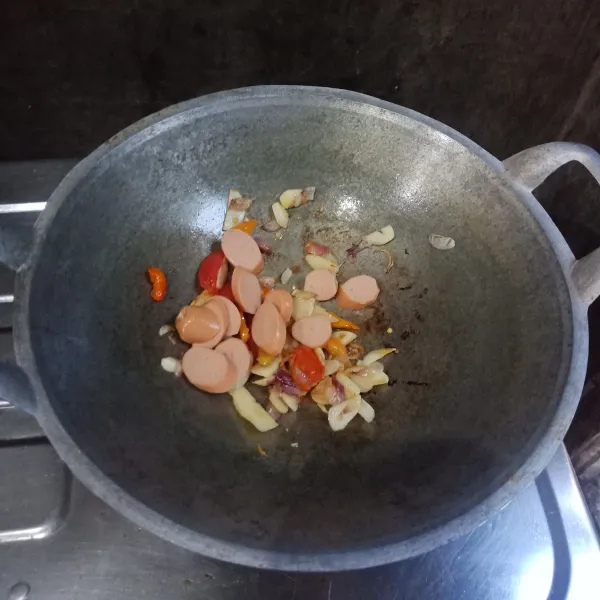 Masukkan sosis ayam, aduk sampai tercampur dengan bumbu.