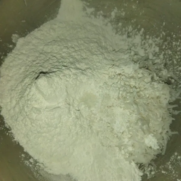 Siapkan kelapa yang diparut dengan parutan keju, tambahkan tepung beras, garam dan tepung sagu.