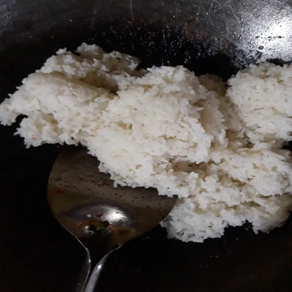 Tambahkan nasi. Aduk rata dan kecilkan api kompor.