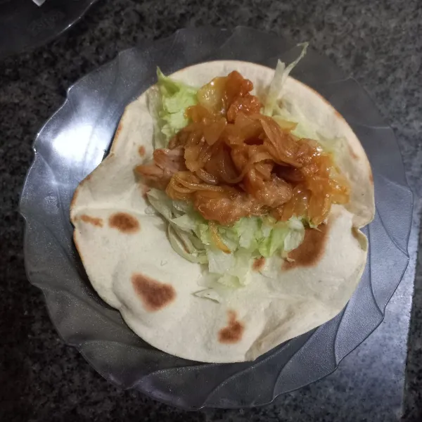 Tata irisan lettuce dan ayam saus madu pada kulit kebab.