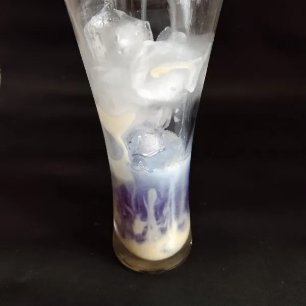Tuang sirup telang ke dalam gelas saji