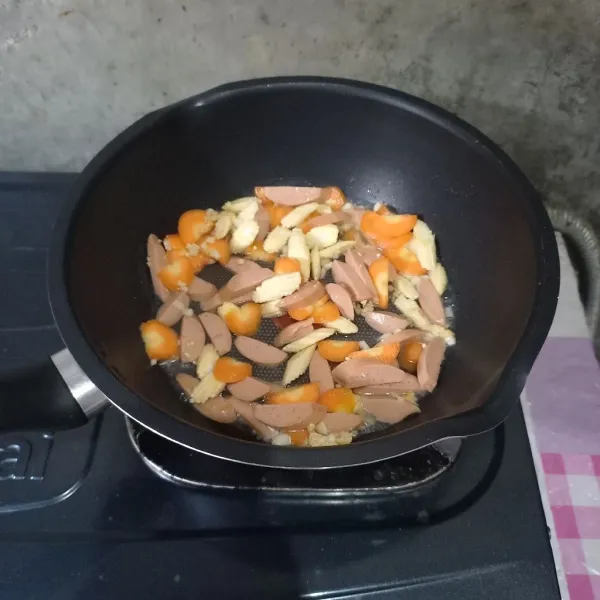 Masukkan air, wortel, putren, dan sosis. Masak sampai wortel setengah matang.