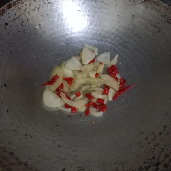 Tumis irisan bawang putih, bawang bombay dan cabe merah keriting hingga harum.