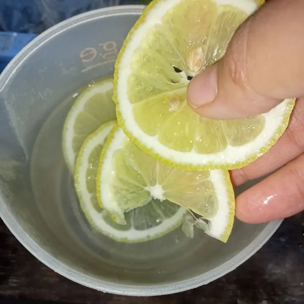 Masukkan air panas dalam gelas lalu masukkan irisan lemon.