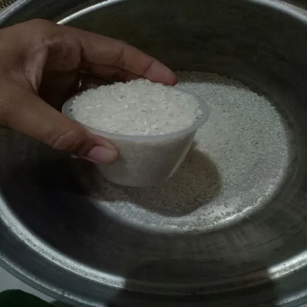 Tuang beras ke dalam panci lalu cuci bersih beras.
