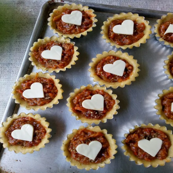 Setelah 20 menit, keluarkan crust dari oven, lalu tuang adonan filling tadi di atas crust, ratakan dan beri potongan keju sesuai selera.