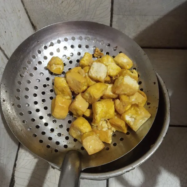 Potong tahu menjadi empat bagian, lalu goreng hingga berkulit.