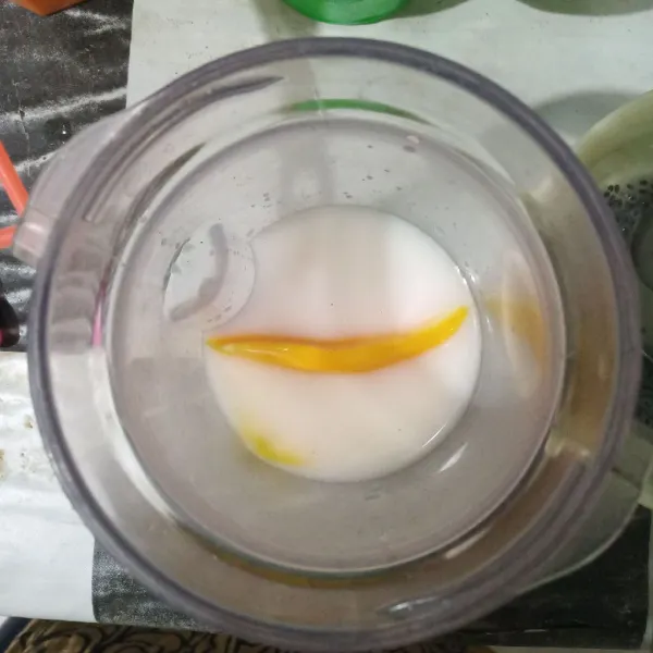 Masukkan potongan mangga dan susu cair kedalam blender.