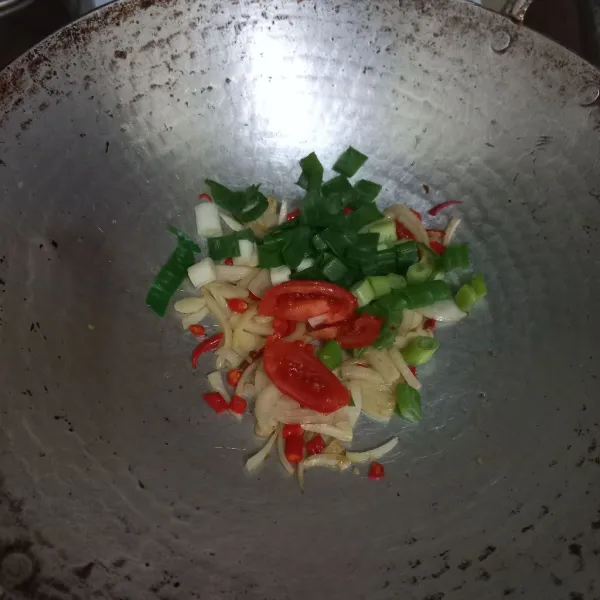 Masukkan irisan tomat dan daun bawang, aduk rata.