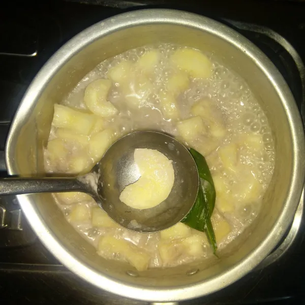 Rebus singkong bersama 500 ml santan dan daun pandan sampai singkong empuk dan merekah.