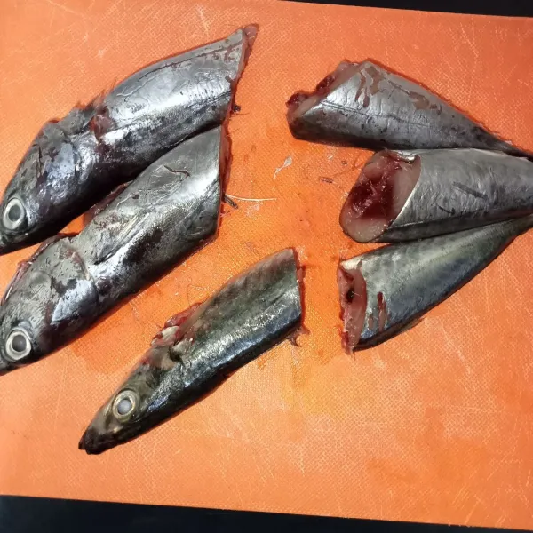Buang isi perut ikan, lalu cuci bersih dan potong ikan menjadi dua.