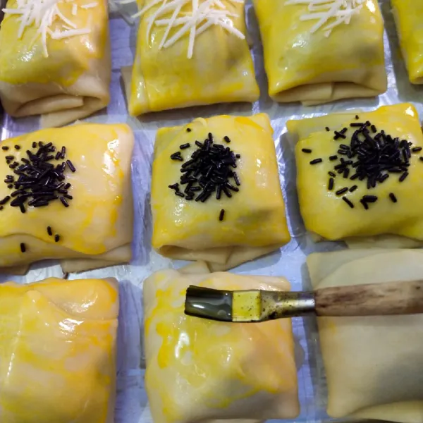 Kemudian olesi dengan kuning telur dan taburi coklat meses dan keju, panggang di suhu 200°C api atas dan bawah selama 40 menit hingga matang dan siap disajikan.