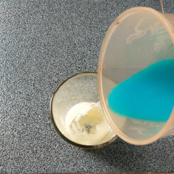 Tambahkan sirup biru ke dalam gelas.