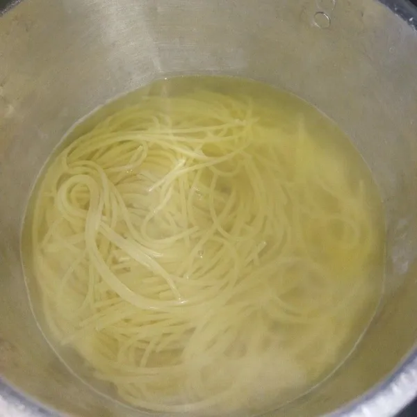 Masak air secukupnya hingga mendidih, lalu masukkan 1 sdt garam dan spaghetti, aduk rata, jika spaghetti sudah terendam, rebus sekitar 10 menit hingga matang.
