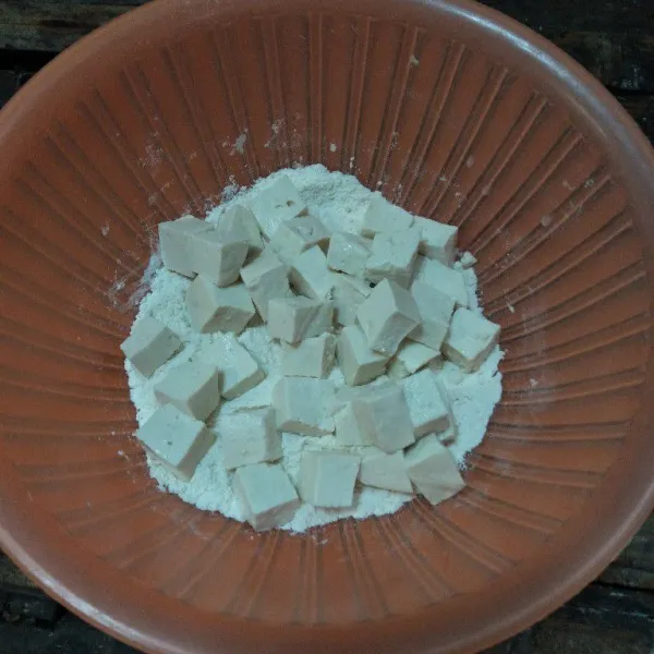 Siapkan wadah, aduk rata maizena beserta seluruh bumbu, kemudian masukan potongan tahu ke dalam tepung.