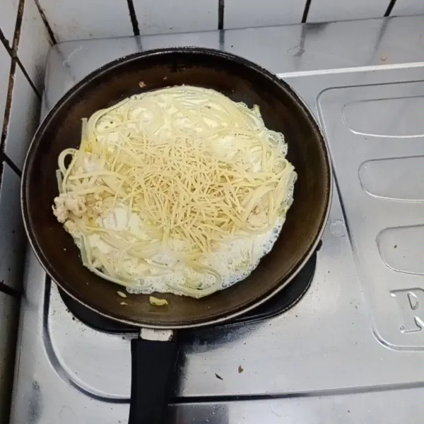 Tambahkan keju parut dan kaldu ayam. 
Aduk rata. 
Masukkan telur. 
Aduk cepat. 
Masak hingga kuah mengental. 
Koreksi rasa dan beri taburan parsley di atasnya. 
Siap dinikmati.