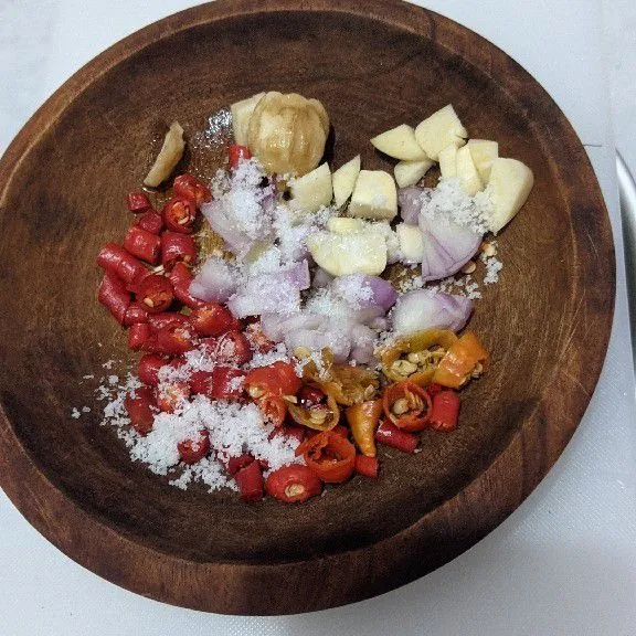 Ulek cabai merah keriting, cabai rawit, bawang merah, bawang putih, ketumbar dan kemiri sampai halus, beri garam.