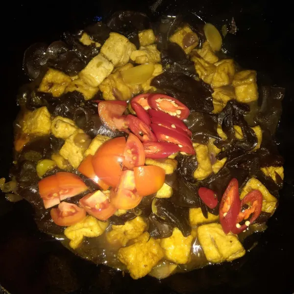 Tambahkan tomat dan cabai merah besar. Masak sebentar sampai layu, lalu angkat dan sajikan.