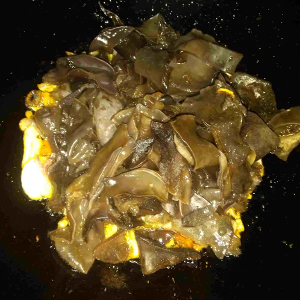 Masukkan jamur kuping dan aduk sampai layu. Tambahkan air, lalu masak hingga mendidih.