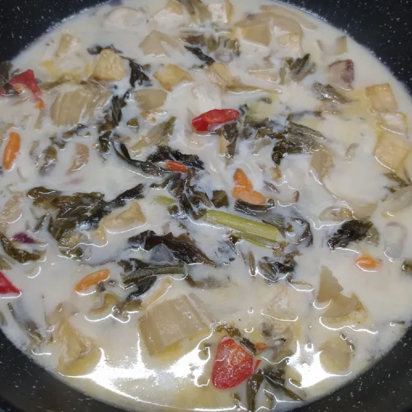 Masukkan santan instan, lalu bumbui dengan garam dan gula pasir. Aduk rata sambil cicipi rasanya sesuai selera. Masak sampai kerang matang, lalu angkat dan sajikan.