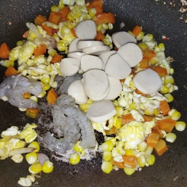Masukkan wortel, jagung, bakso ikan, dan udang, lalu aduk rata. Masak hingga udang berubah warna.