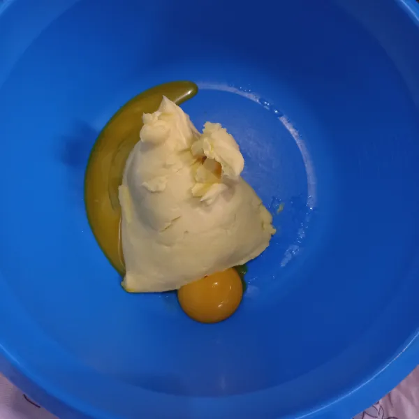 Siapkan wadah, kemudian campurkan kuning telur dan margarin. Lalu aduk sampai tercampur rata.