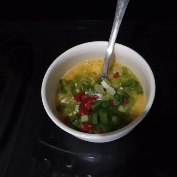 Masukkan daun bawang, cabai, dan bumbu halus, lalu aduk rata.