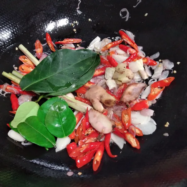 Masukkan cabe merah, cabe rawit, daun salam, daun jeruk, lengkuas, serai, kencur dan jahe, tumis hingga layu dan harum.