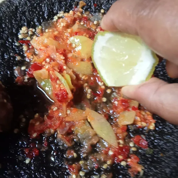 Tambahkan irisan tomat dan ulek lagi, beri perasan jeruk dan cicipi rasanya. 
Sajikan ikan bakar dengan sambalnya.