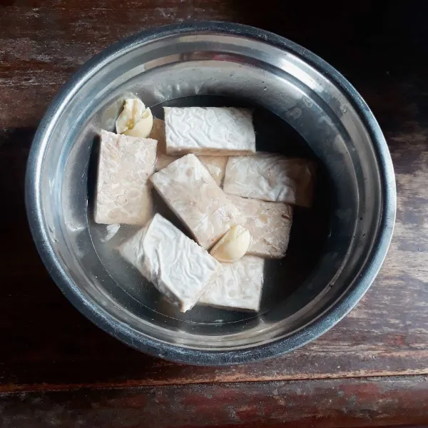 Potong tempe menjadi 8 bagian. Campurkan tempe, bawang putih, ketumbar, garam, dan merica, tambahkan sedikit air agar tempe terendam. Diamkan 1 jam.