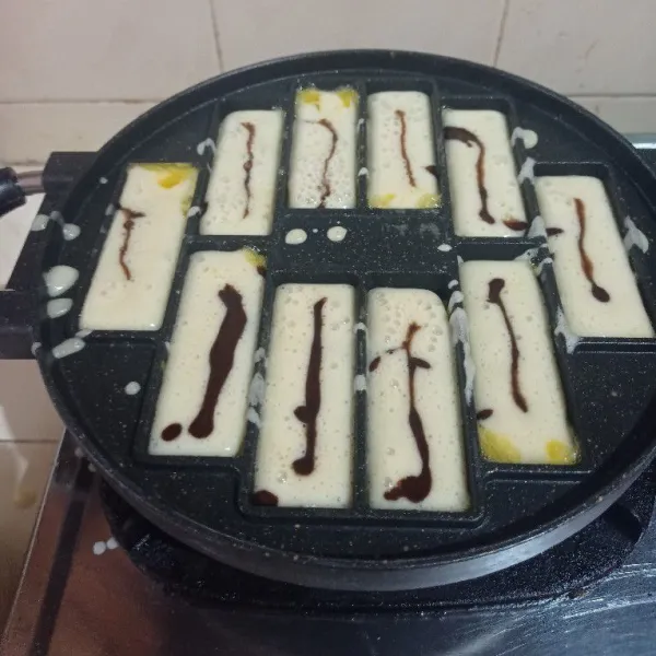 Panaskan cetakan pukis, ambil adonan putih dan beri pasta coklat, aduk rata. Masukkan adonan ke cetakan 3/4 bagian dari cetakan kemudian beri adonan coklat.